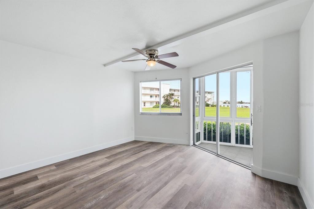 An empty room with wood-look flooring, a ceiling fan, and a sliding glass door — 769 JOHN RINGLING BOULEVARD UNIT 4, SARASOTA, FL