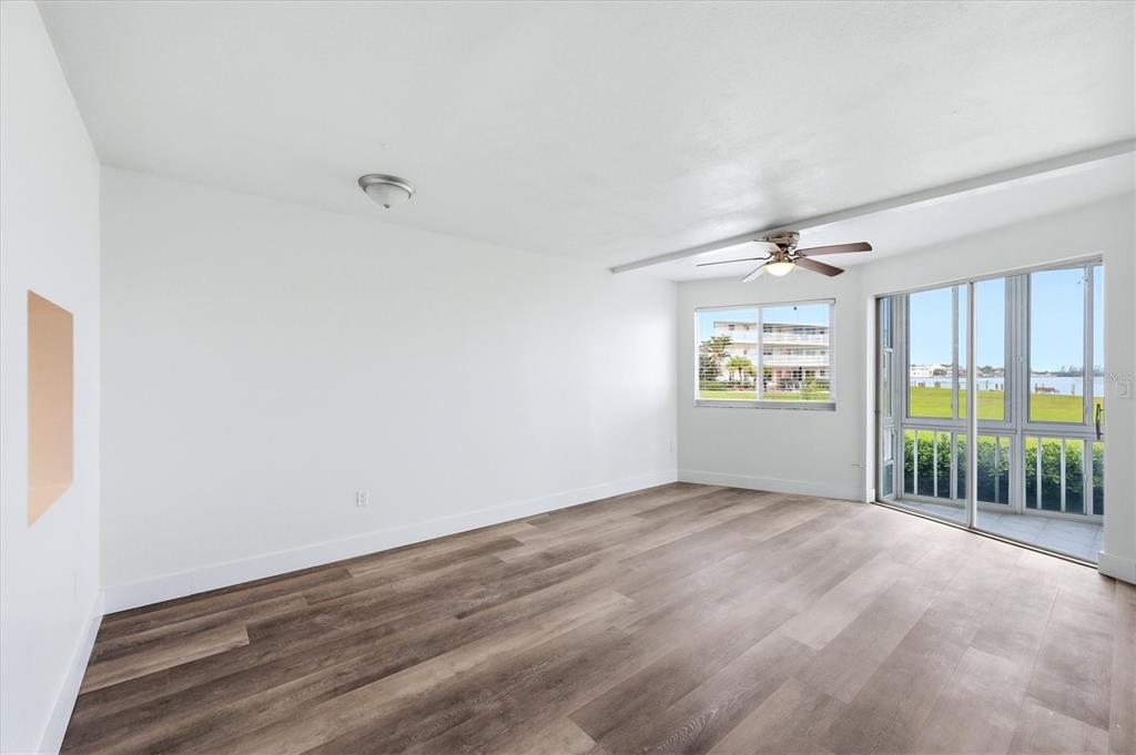 An empty room with white walls, wood-look flooring, a ceiling fan, and a sliding glass door — 769 JOHN RINGLING BOULEVARD UNIT 4, SARASOTA, FL
