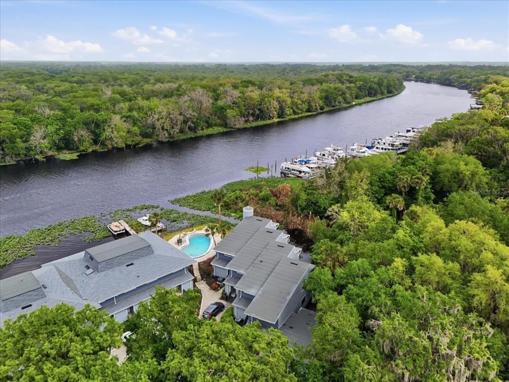 An aerial view shows a multi-unit building with a pool next to a river — 2329 RIVER RIDGE ROAD UNIT 2, DELAND, FL