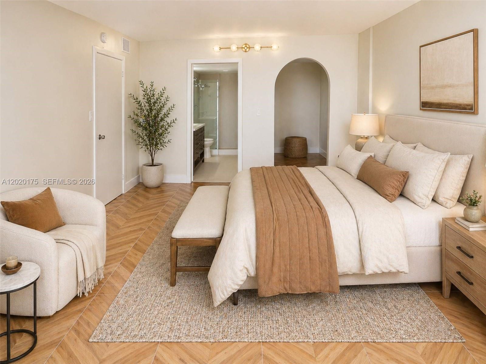 A bedroom features a bed, armchair, arched doorway, and herringbone wood flooring — 2500 Parkview Dr # 1816, Hallandale Beach FL 33009, HALLANDALE BEACH, FL