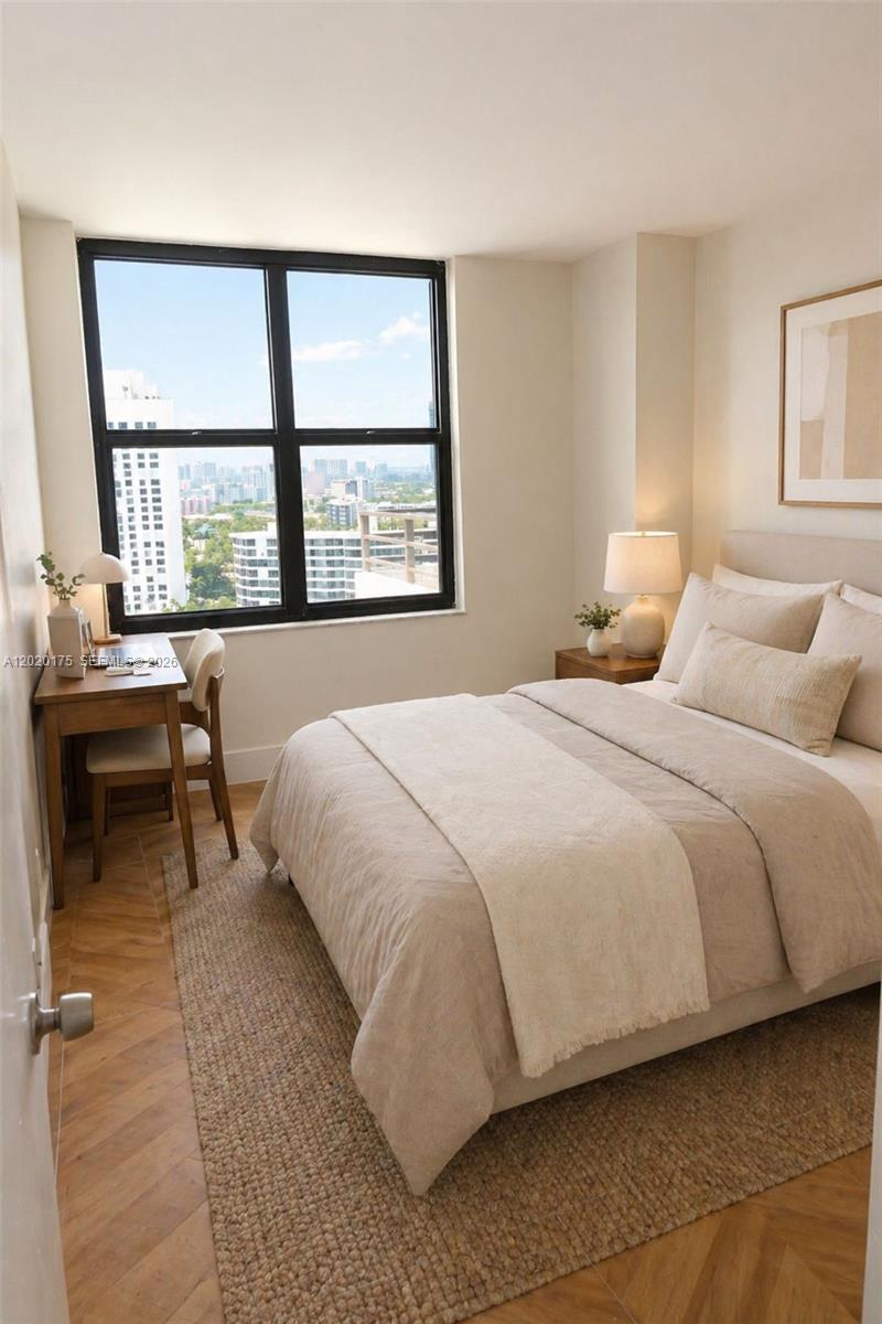 A bedroom features a bed, a desk by a window with city views, and wood flooring — 2500 Parkview Dr # 1816, Hallandale Beach FL 33009, HALLANDALE BEACH, FL