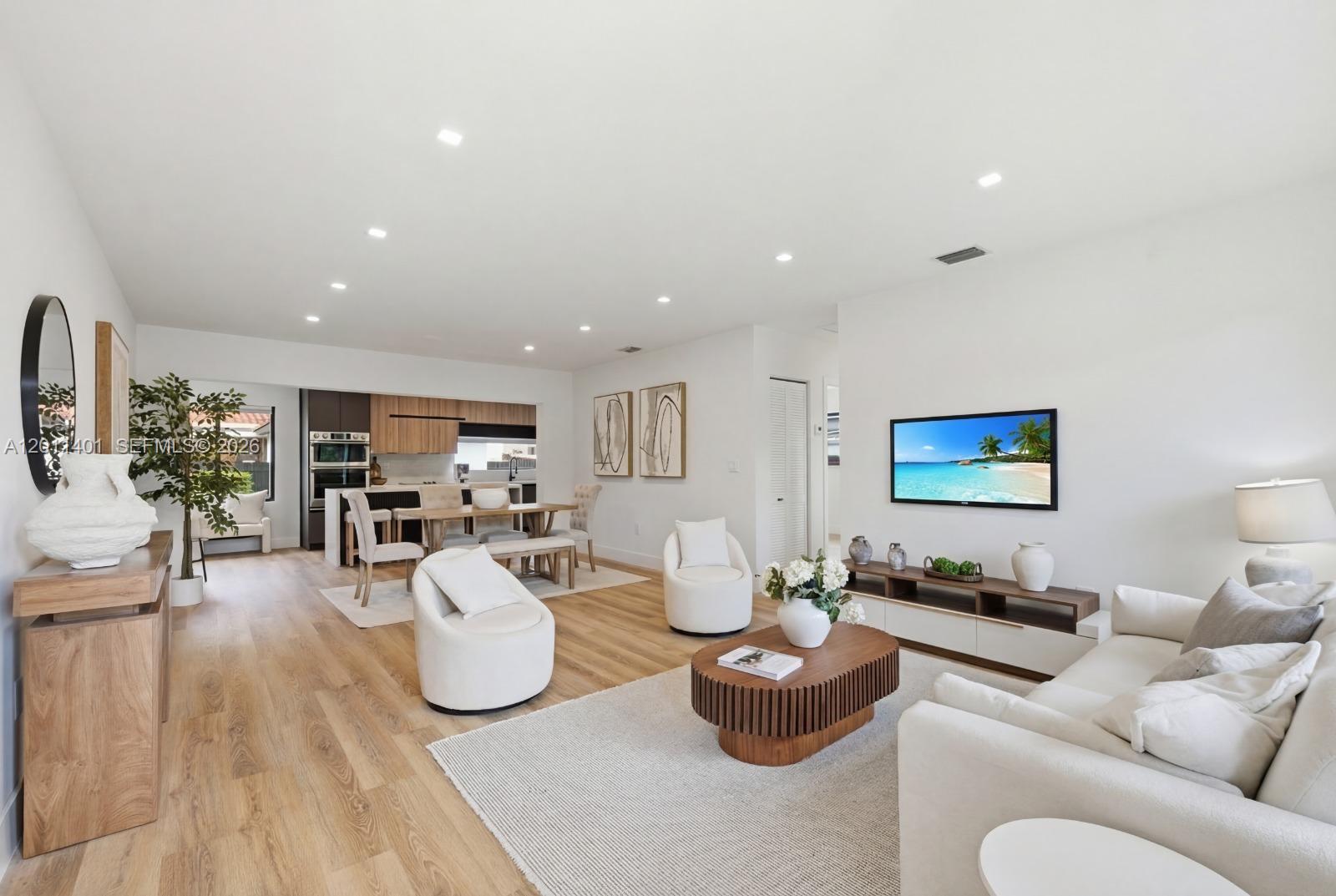 A bright, open-concept living and dining area features light wood flooring and modern neutral furniture — 3021 SW 12th St, Miami FL 33135, MIAMI, FL