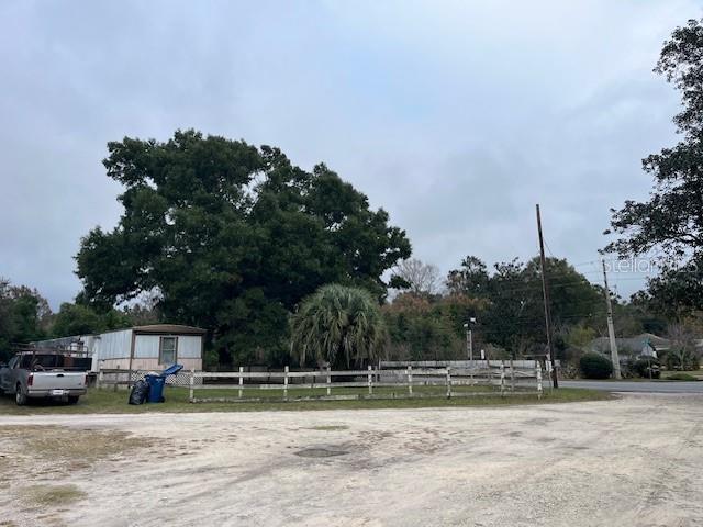 A mobile home sits behind a white fence next to a large tree — 13730 NW 140TH STREET, ALACHUA, FL