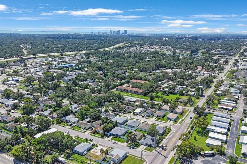 An aerial view shows a suburban neighborhood with houses, streets, and a distant city skyline — 2753 53RD AVENUE N, ST PETERSBURG, FL