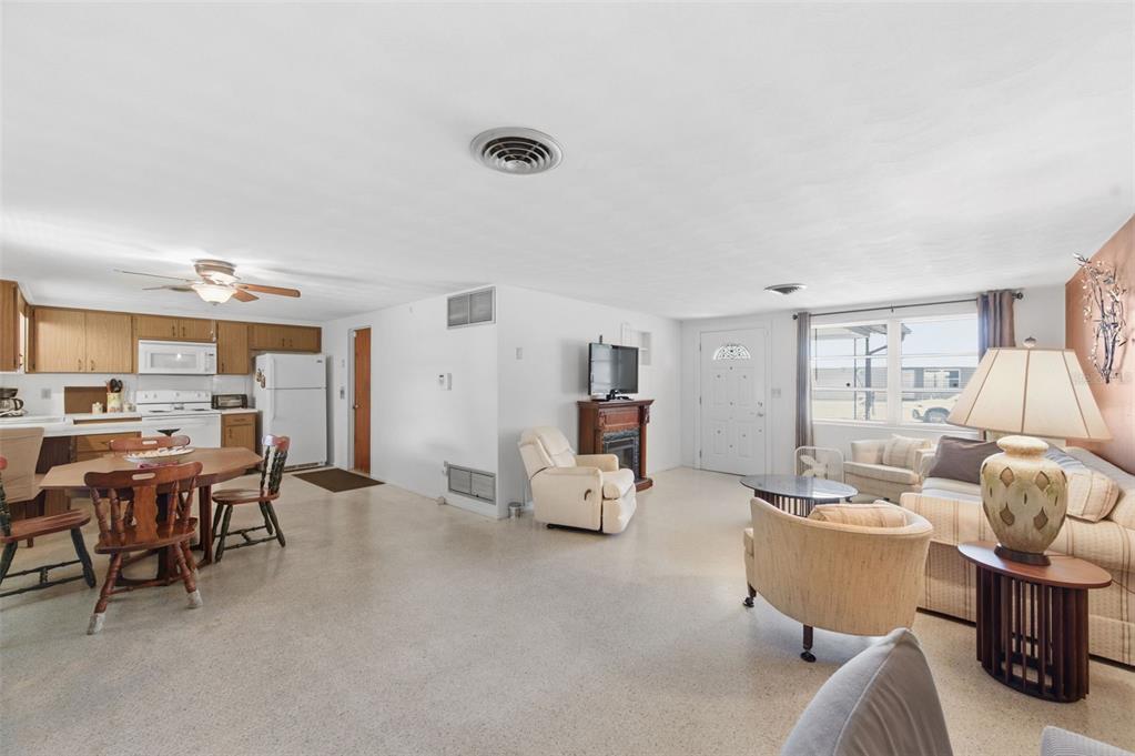 An open-concept living room and kitchen with light-colored flooring and a white ceiling — 3904 REDWOOD DRIVE, HOLIDAY, FL