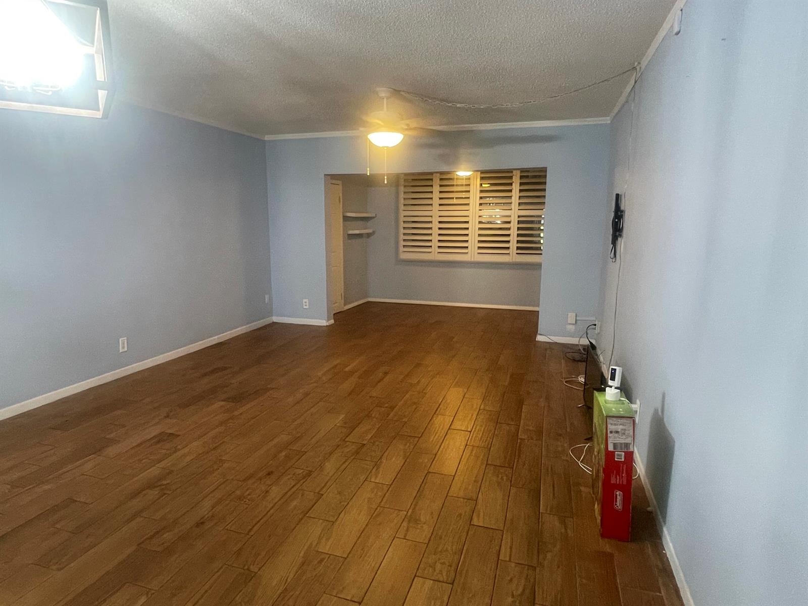 An empty room features light blue walls, wood-look tile flooring, and a ceiling fan — 752 Lori Drive # 223, Palm Springs FL 33461, PALM SPRINGS, FL