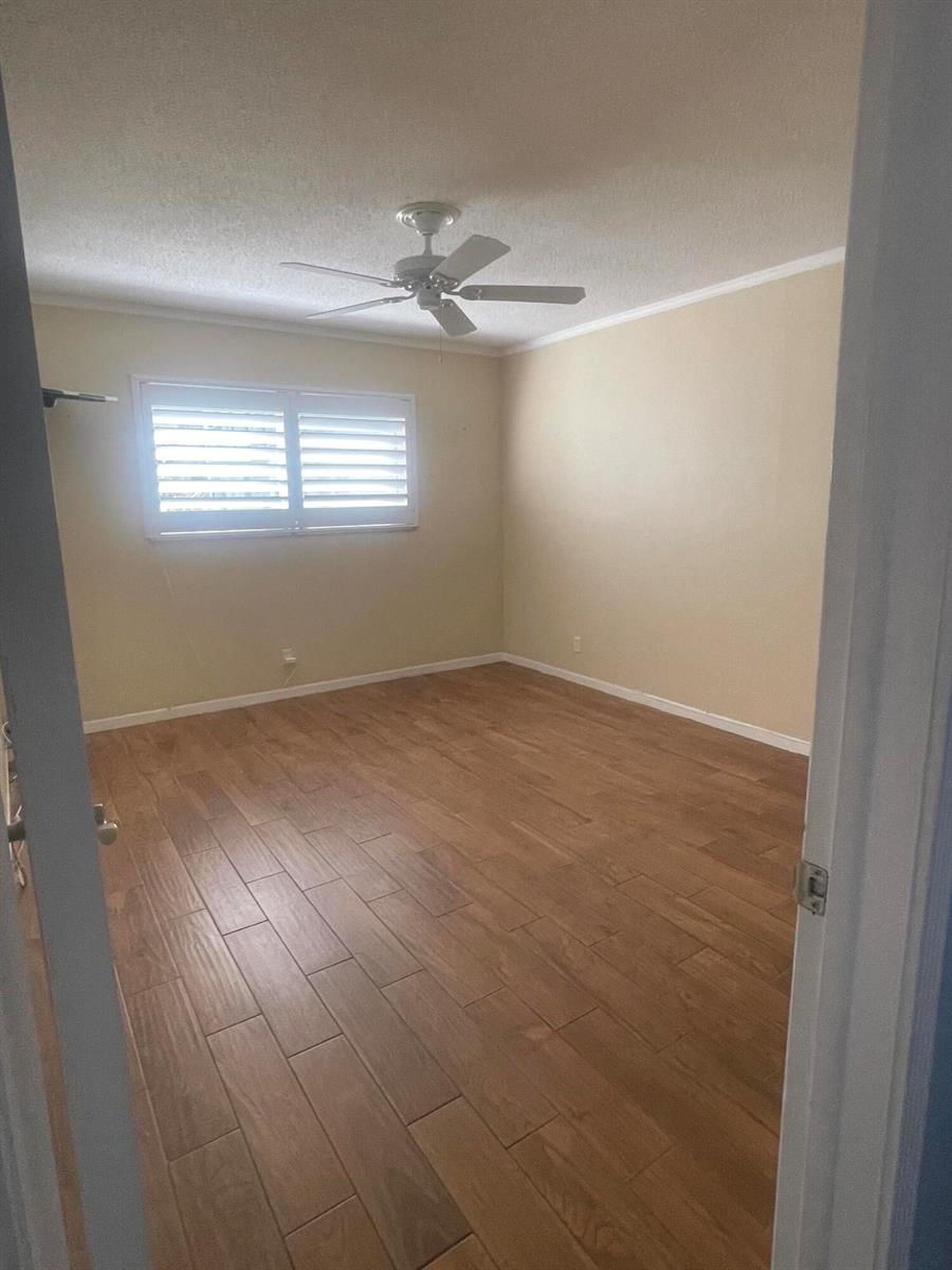 An empty bedroom features light-colored walls, a ceiling fan, and wood-look tile flooring — 752 Lori Drive # 223, Palm Springs FL 33461, PALM SPRINGS, FL