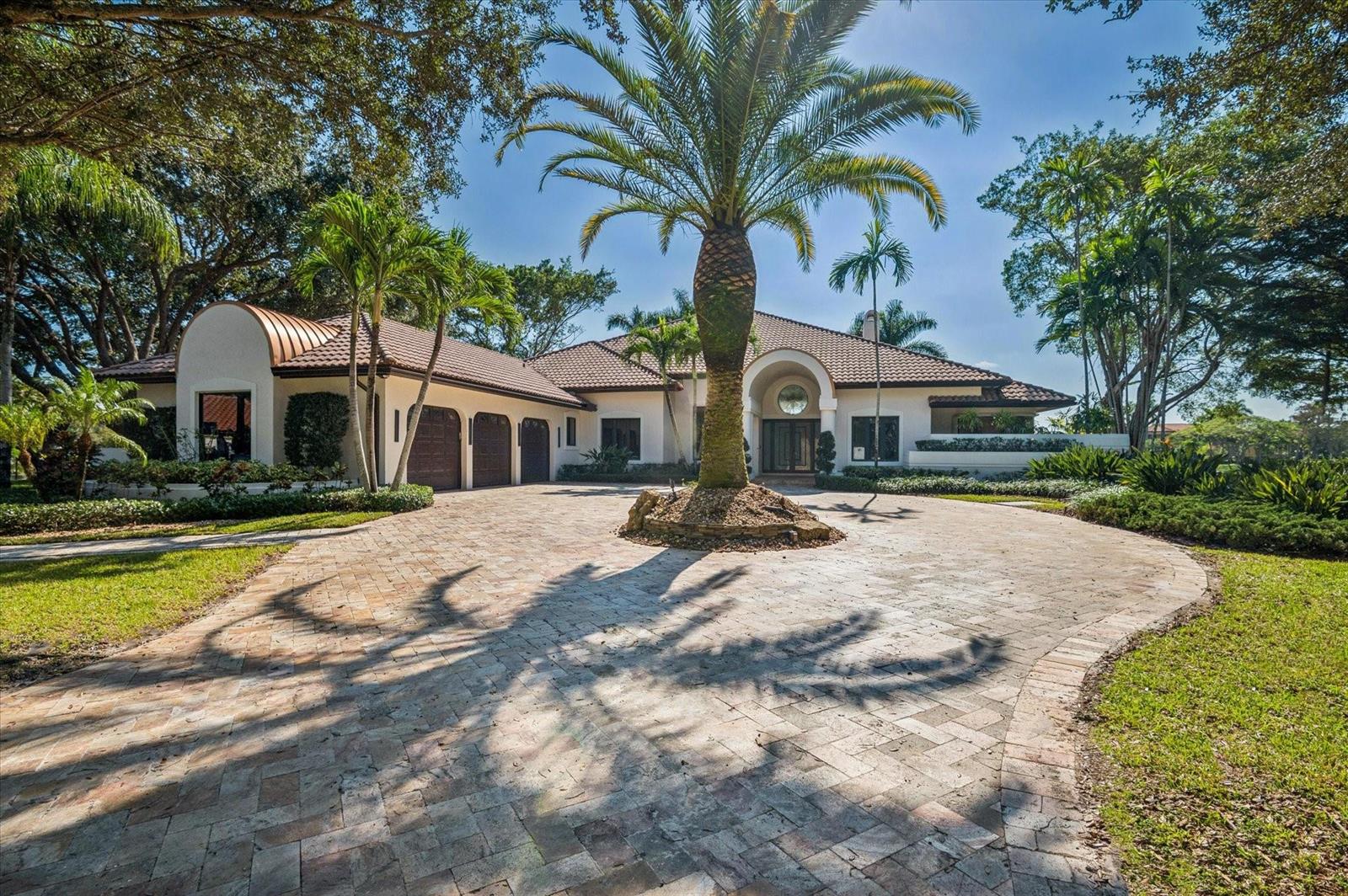 A single-story house with a circular driveway, a central palm tree, and a tiled roof — 7600 Hyannis Lane, Parkland FL 33067, PARKLAND, FL