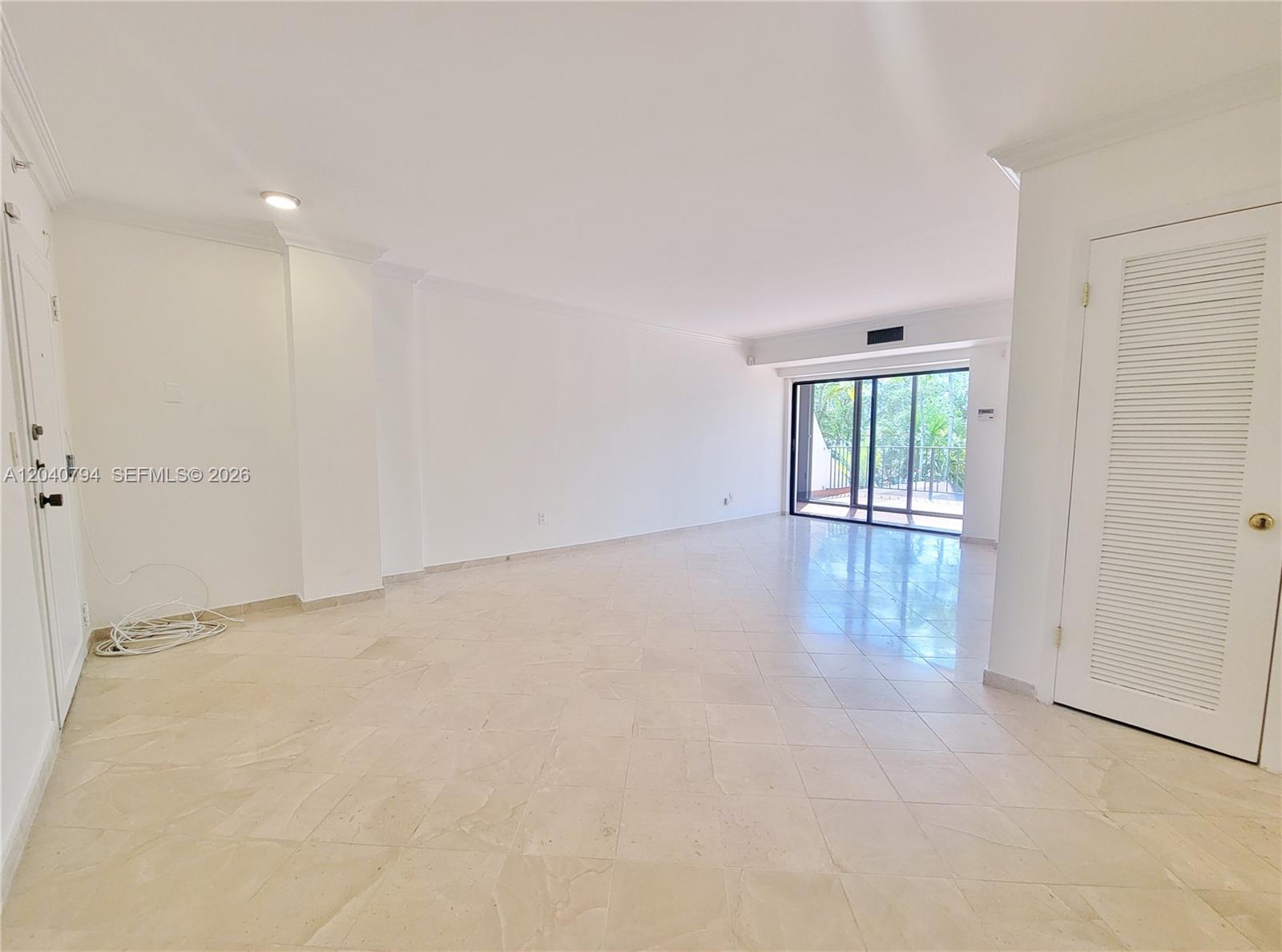 An empty room features white walls, a tiled floor, and a white entry door — 77 Crandon Blvd # 2B, Key Biscayne FL 33149, KEY BISCAYNE, FL
