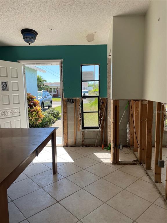 An interior room with tiled floors, a teal wall, and exposed wall studs under construction — 13612 FRANCES AVENUE, HUDSON, FL