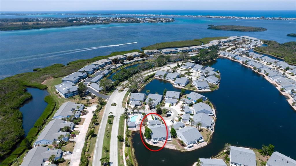 An aerial view shows a residential community with a red circle highlighting a specific building — 1011 IBIS COURT, BRADENTON, FL