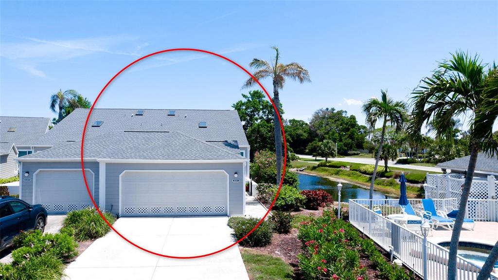 An exterior view of a gray house with a two-car garage and a shingled roof — 1011 IBIS COURT, BRADENTON, FL