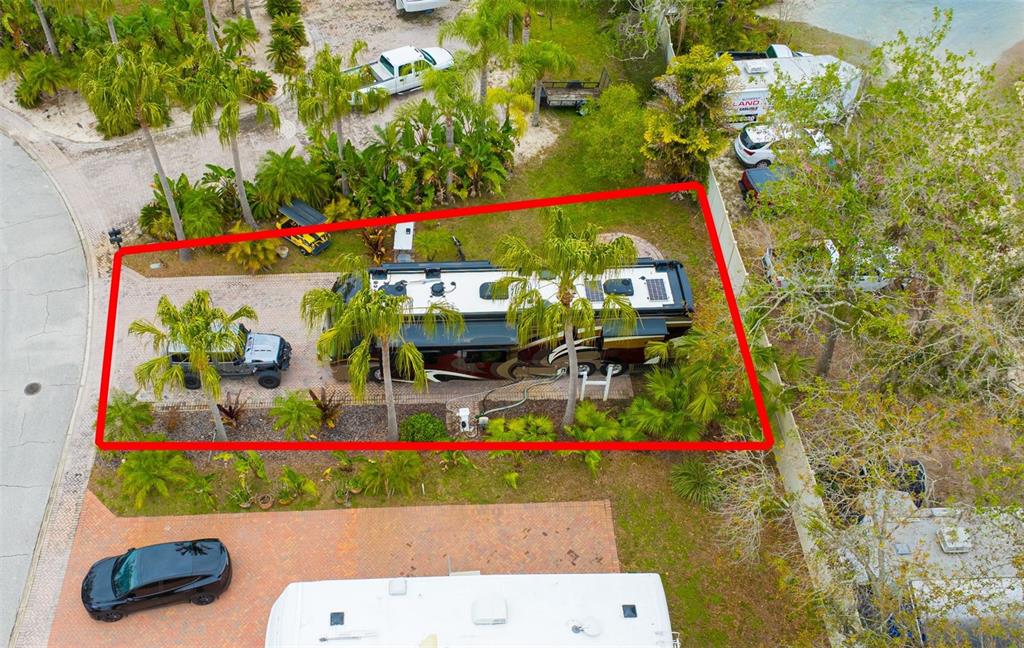 An aerial view shows a paved lot with a large motorhome and a parked Jeep — 6865 AMANDA VISTA CIRCLE, LAND O LAKES, FL
