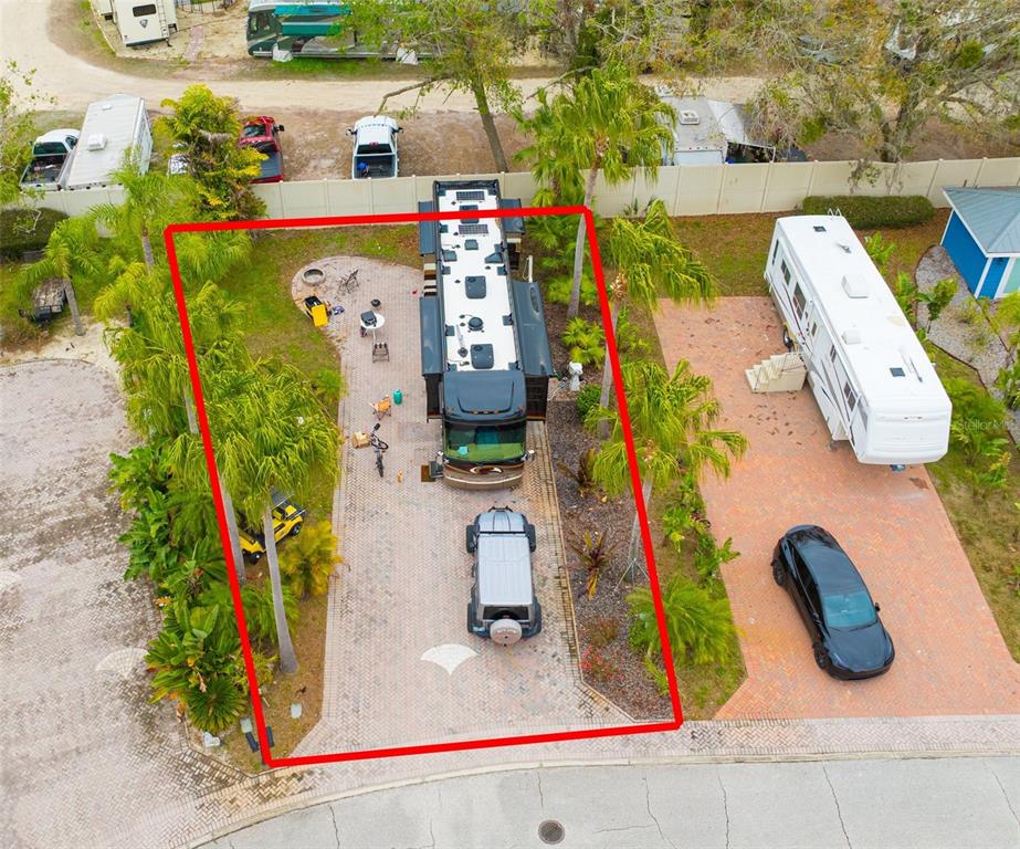 An aerial view shows a paved RV lot with a motorhome, a car, and landscaping — 6865 AMANDA VISTA CIRCLE, LAND O LAKES, FL
