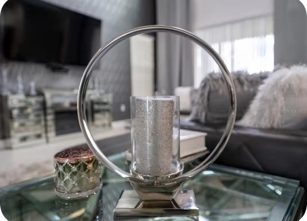 A silver circular candle holder sits on a glass coffee table in a living room — 621 DROP SHOT DRIVE, DAVENPORT, FL