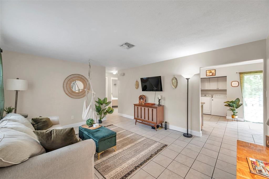 A living room features tile flooring, a hanging chair, a television, and a laundry area — 3371 N BAY AVENUE, CRYSTAL RIVER, FL