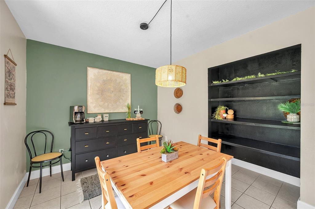A dining room features a wooden table, black dresser, built-in shelving, and green accent wall — 3371 N BAY AVENUE, CRYSTAL RIVER, FL