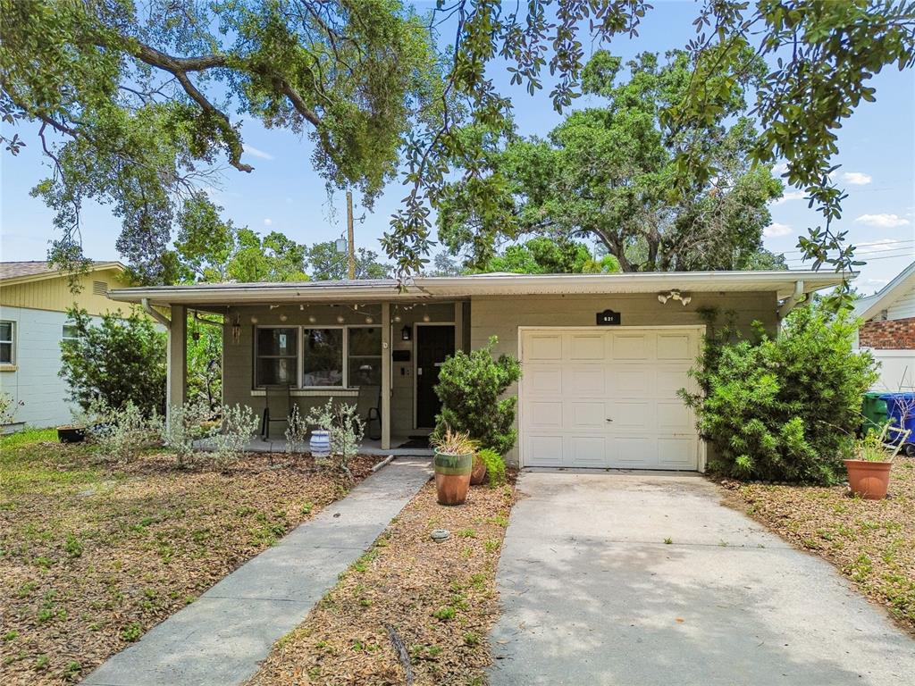 A single-story house with a white garage door, a front porch, and a concrete driveway — 621 E DAVIS BOULEVARD, TAMPA, FL