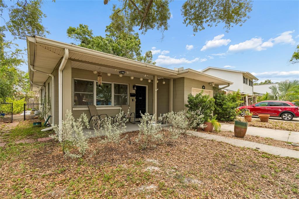 A single-story house with a covered front porch, tan siding, and a red car parked nearby — 621 E DAVIS BOULEVARD, TAMPA, FL