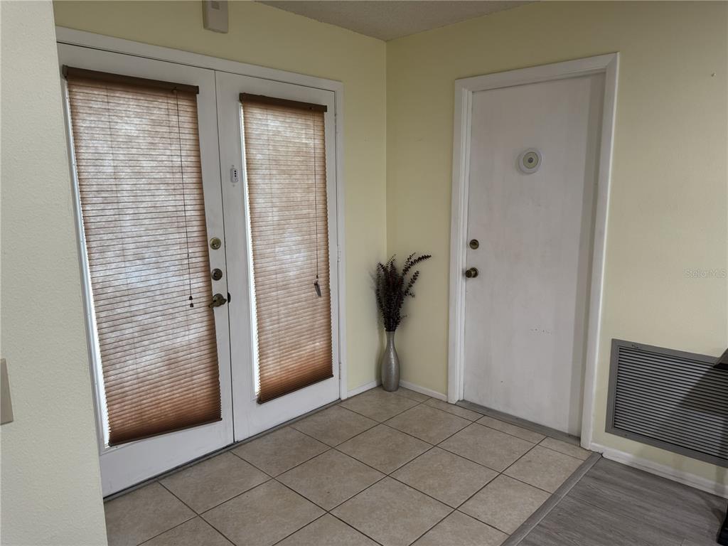An entryway features tile flooring, a white door, and a set of glass-paned double doors — 11220 ELDERBERRY DRIVE, PORT RICHEY, FL