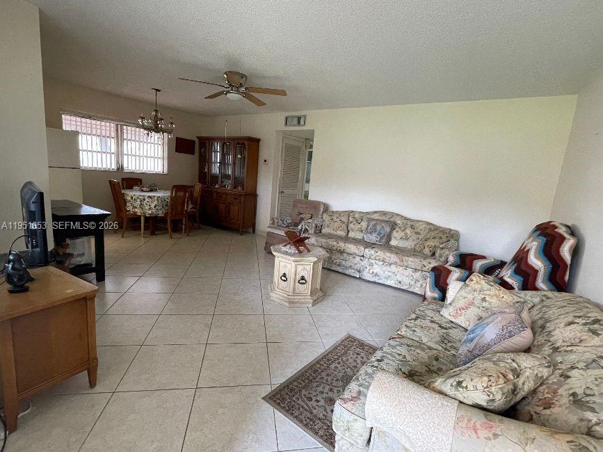 A living room and dining area feature light tile flooring and floral-patterned furniture — 5300 Washington St # S111, Hollywood FL 33021, HOLLYWOOD, FL
