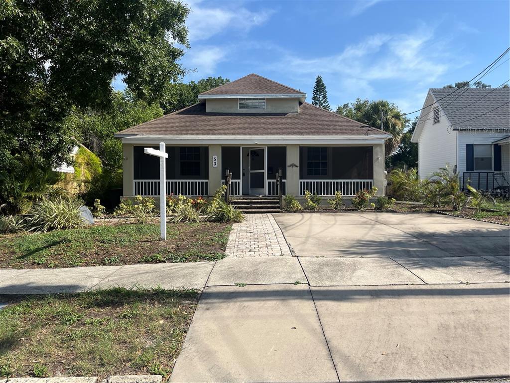 A single-story house with a screened front porch, a paved walkway, and a concrete driveway — 53 W PARK STREET, TARPON SPRINGS, FL