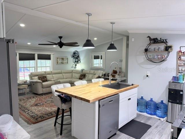 A kitchen island with a wood countertop sits before a living area with a sectional — 23065 SW 119TH PLACE, DUNNELLON, FL