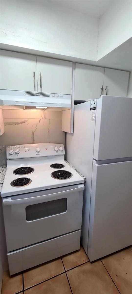 A kitchen features white appliances, white cabinets, and a marble-patterned backsplash — 7851 Dunham Blvd # 12, Miami FL 33138, MIAMI, FL