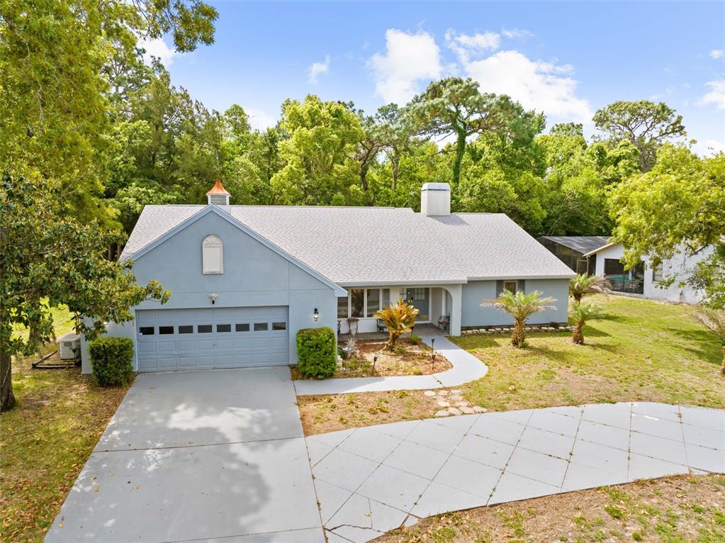 A light blue single-story house with a two-car garage and a paved driveway — 5 CHINKAPIN CIRCLE, HOMOSASSA, FL