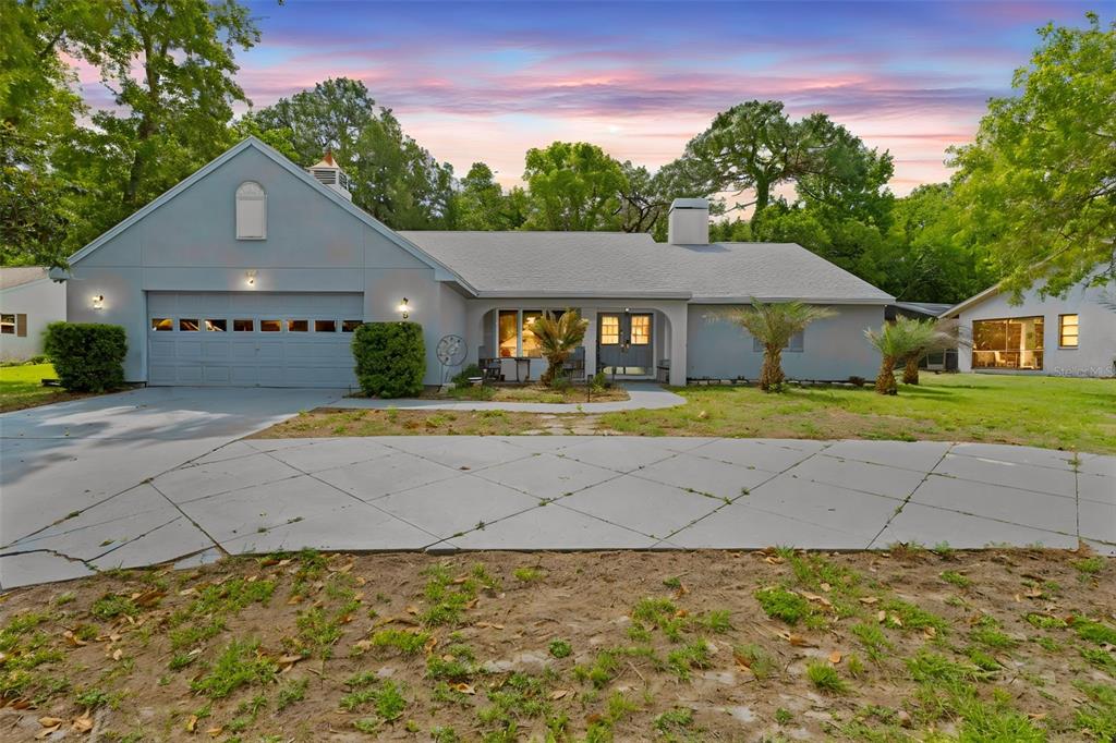 A single-story house with a gray exterior, a two-car garage, and a large concrete driveway — 5 CHINKAPIN CIRCLE, HOMOSASSA, FL