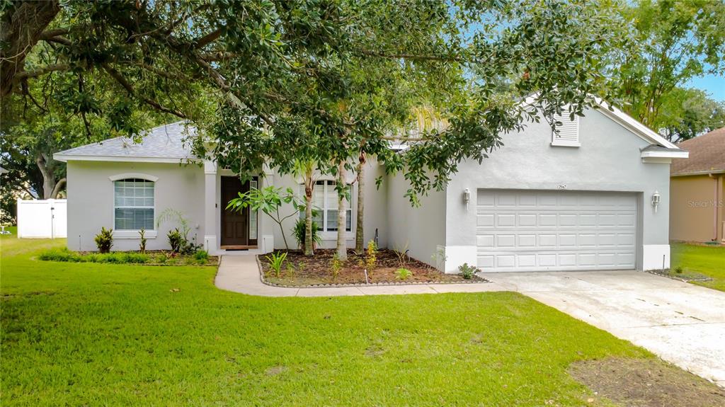 A single-story house with a gray exterior, a two-car garage, and a front lawn — 2947 MAJESTIC ISLE DRIVE, CLERMONT, FL