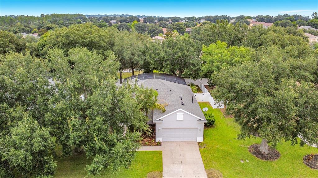 An aerial view shows a single-story house with a two-car garage and a screened-in pool — 2947 MAJESTIC ISLE DRIVE, CLERMONT, FL
