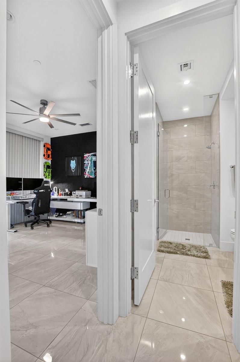 A view through a doorway showing a home office and an adjacent tiled bathroom — 4021 NW 18th Way, Boca Raton FL 33431, BOCA RATON, FL
