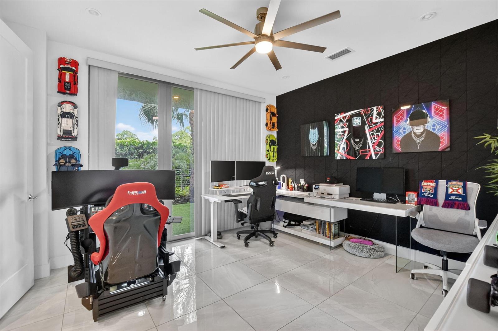 A home office features a racing simulator, dual desks, wall art, and large floor tiles — 4021 NW 18th Way, Boca Raton FL 33431, BOCA RATON, FL