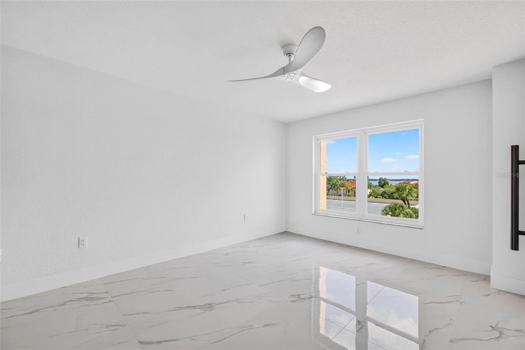An empty room with white walls, a ceiling fan, and white marble-look tile flooring — 4900 BRITTANY DRIVE S UNIT 405, ST PETERSBURG, FL