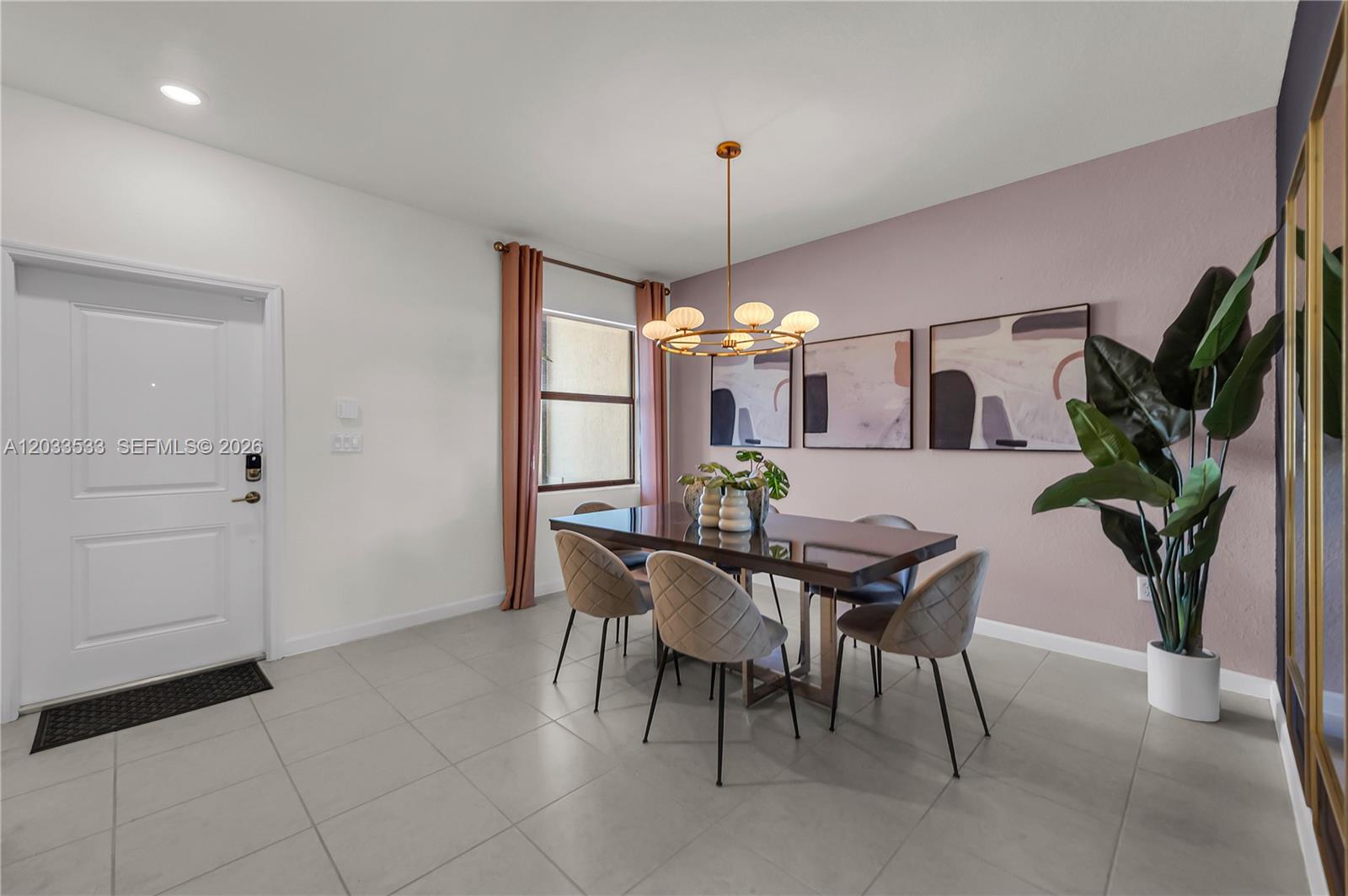 A dining room features a dark table, upholstered chairs, a chandelier, and a mauve accent wall — 12976 SW 233rd Ter, Homestead FL 33032, HOMESTEAD, FL