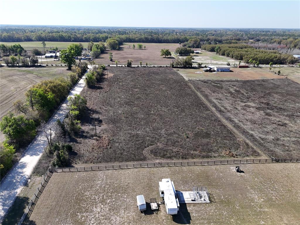 An aerial view shows a large, cleared rectangular lot bordered by a fence and road — NW 50 STREET, BELL, FL