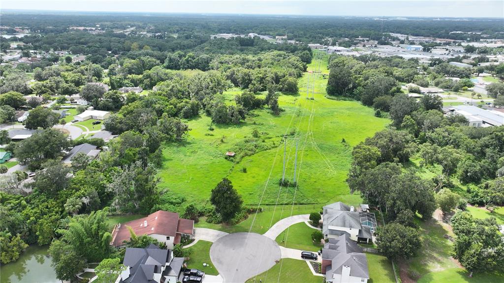 An aerial view shows a residential cul-de-sac bordering a large, grassy utility easement with powerlines — BRANNEN ROAD S, LAKELAND, FL