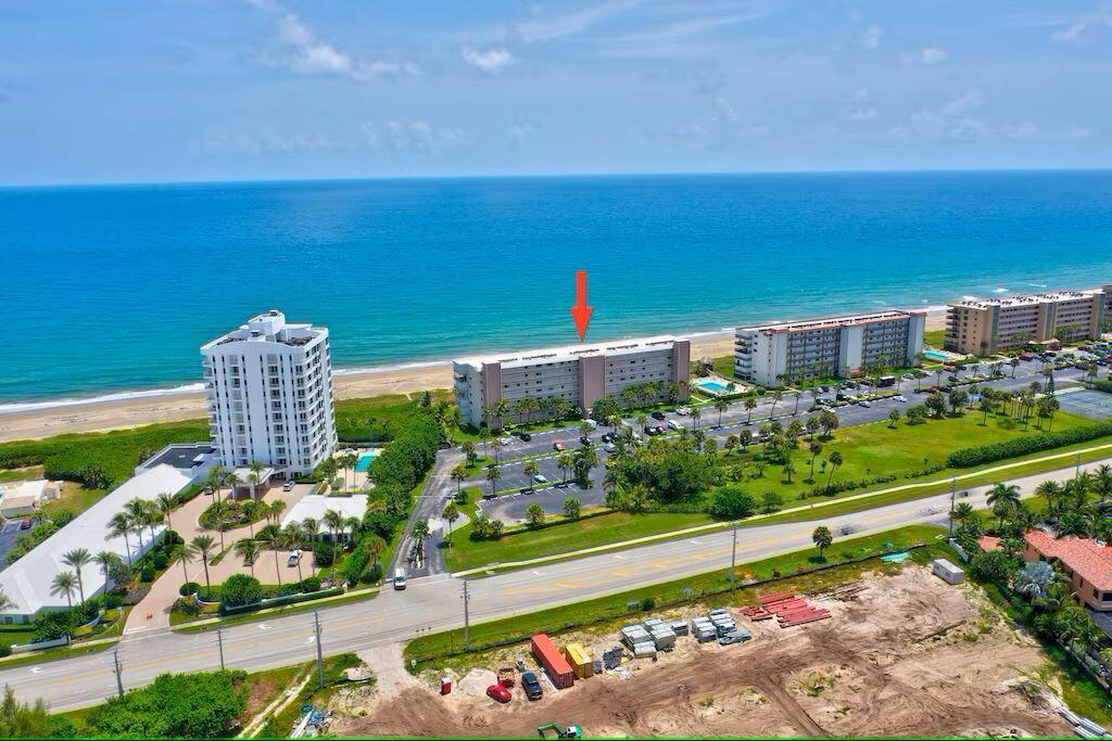 An aerial view of a beachfront condominium complex with a parking lot and ocean view — 10102 S Ocean Drive # 107, Jensen Beach FL 34957, JENSEN BEACH, FL