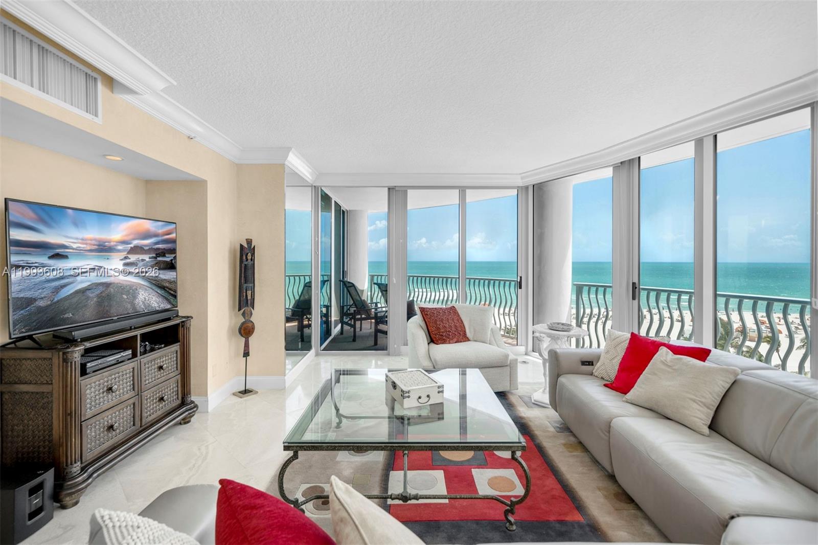 A living room features a glass coffee table, a white sofa, and floor-to-ceiling ocean views — 1500 Ocean Drive # 702, Miami Beach FL 33139, MIAMI BEACH, FL