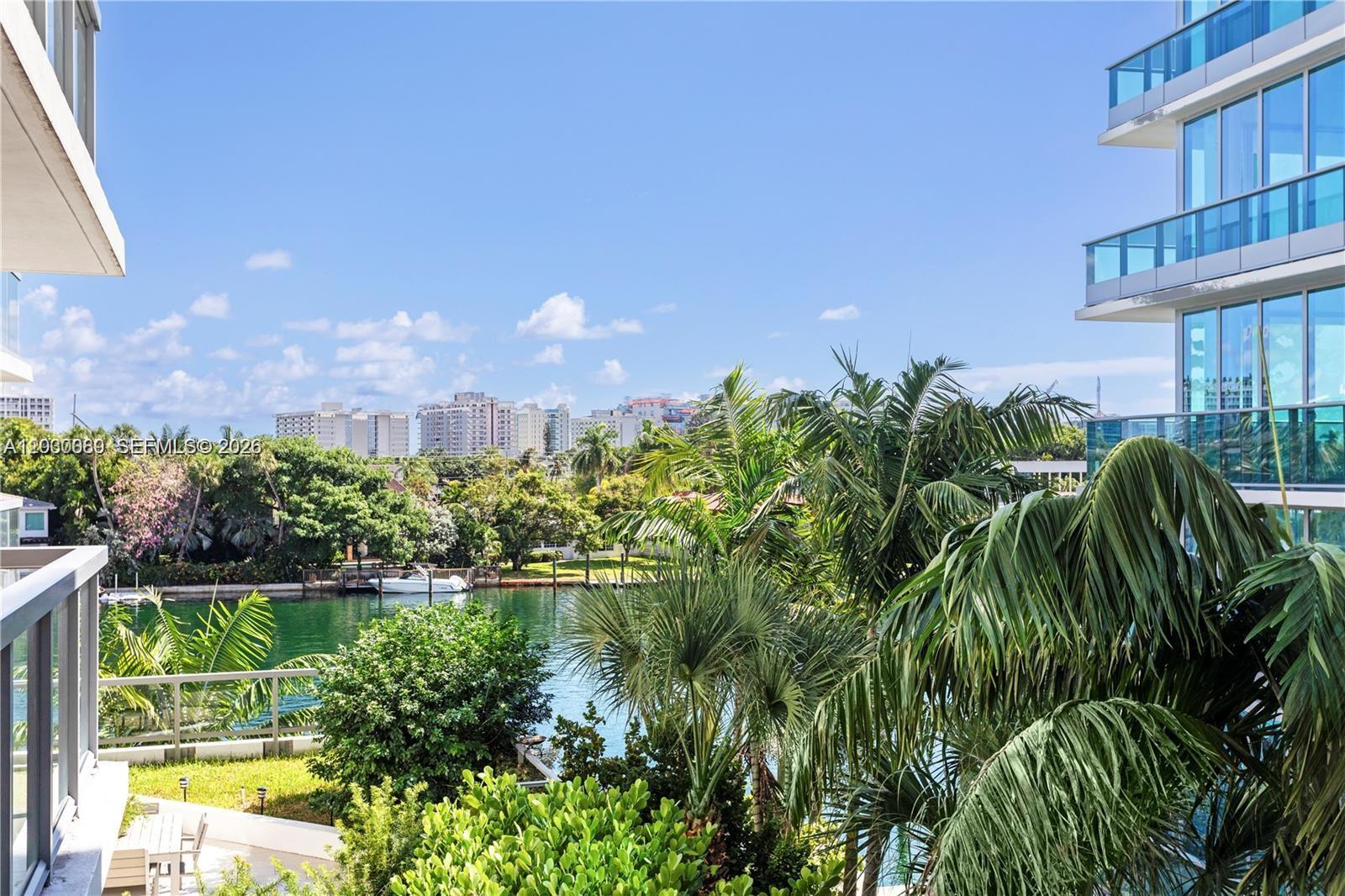 An elevated view of a canal surrounded by lush greenery and modern apartment buildings — 9261 E Bay Harbor Dr # 407, Bay Harbor Islands FL 33154, BAY HARBOR ISLANDS, FL