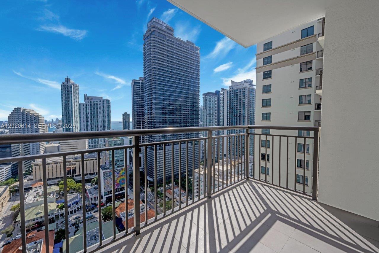 A balcony with a metal railing overlooks a dense urban skyline with several high-rise buildings — 999 SW 1st Ave # 2911, Miami FL 33130, MIAMI, FL