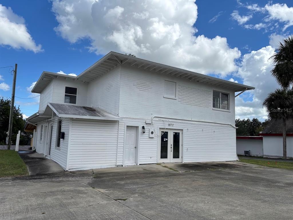 A two-story white building with a concrete parking lot under a cloudy sky — 1871 S RIDGEWOOD AVENUE, SOUTH DAYTONA, FL