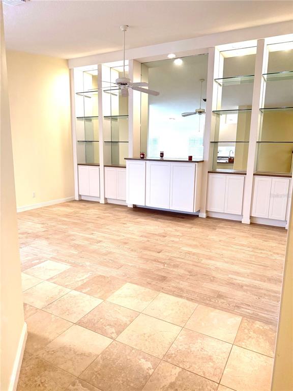 A room features tile flooring, wood-look flooring, built-in white cabinets, and glass shelving — 6214 ERICE STREET, VENICE, FL