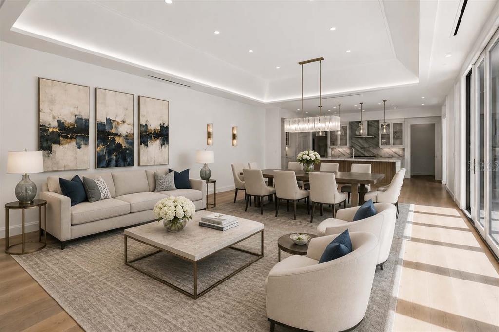 An open-concept living and dining area with neutral furniture, modern lighting, and hardwood floors — 10335 WINTER SPARKLE CIRCLE, GOLDEN OAK, FL