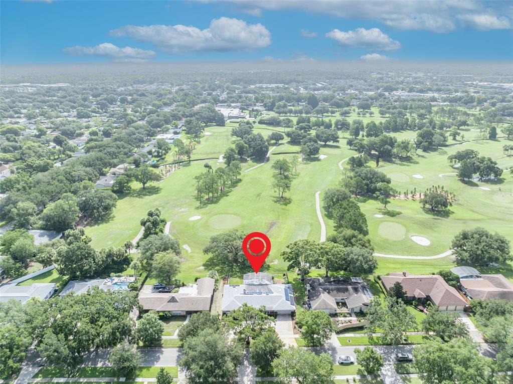 An aerial view shows a residential house with a pool cage overlooking a golf course — 938 GOLFSIDE DRIVE, WINTER PARK, FL