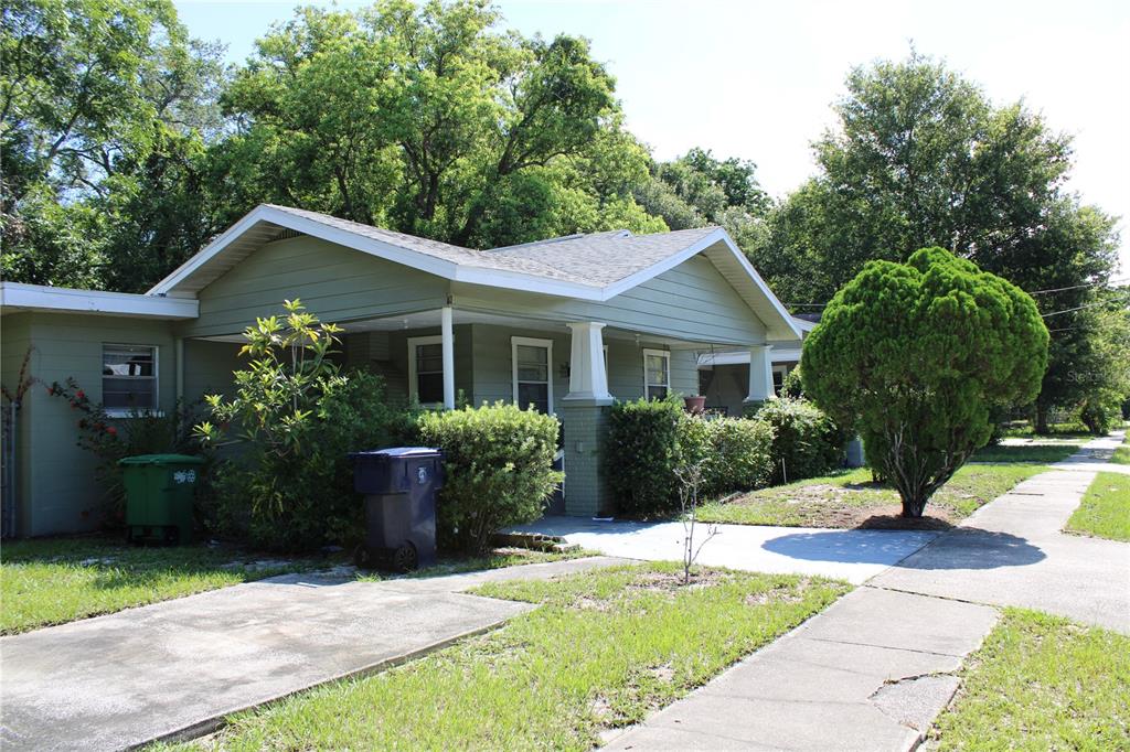 A single-story house with green siding, a front porch, and a concrete driveway — 3504 E 24TH AVENUE, TAMPA, FL