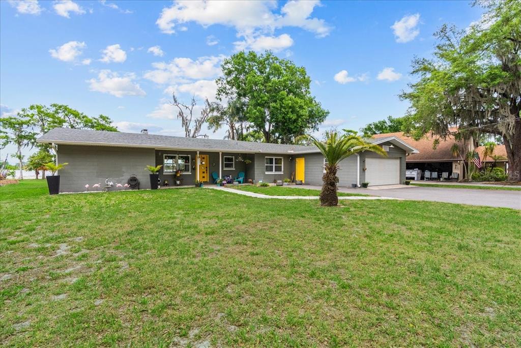 A single-story gray house with a yellow front door and a two-car garage — 4881 LAKE CECILE DR, KISSIMMEE, FL