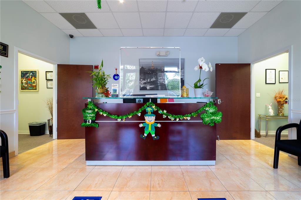A reception desk decorated for St. Patrick's Day sits in a tiled office lobby — 12250 MENTA STREET UNIT 106, ORLANDO, FL