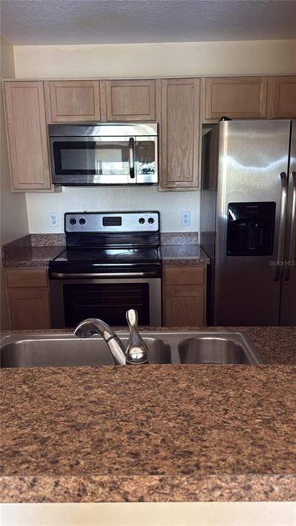 A kitchen features light wood cabinets, stainless steel appliances, and a brown speckled countertop — 3950 SOUTHPOINTE DRIVE UNIT 418, ORLANDO, FL